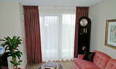Pinch pleat curtains with sheer on a condominium