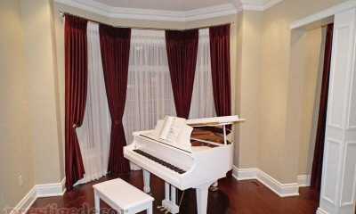 Bay window with luxurious draperies, sheers and iron curtain rods with crystal finials