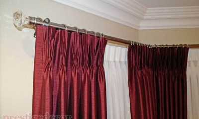 Bay window with luxurious curtains, sheers and iron curtain rods with crystal finials