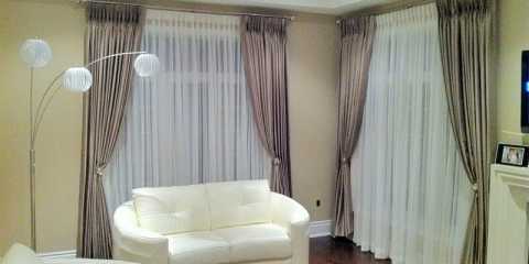 Stylish pinch pleat curtains in the living room with sheers, holdbacks and iron drapery hardware.