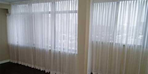 Elegant sheer curtains in the living room and dining of a condo in Toronto