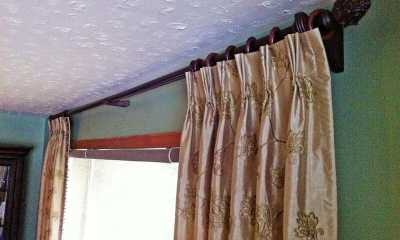 Elegant curtain panels on a wooden curtain rod with wooden finials