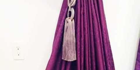 Stunning purple curtains with luxurious tiebacks.