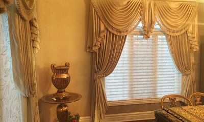 Luxurious window treatments with swags, side panels, shades, and Swarovski crystal holdbacks