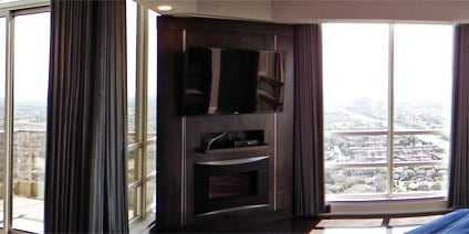 Functional sun-out draperies on a CCS cord track system in the master bedroom of a penthouse condo in Mississauga.