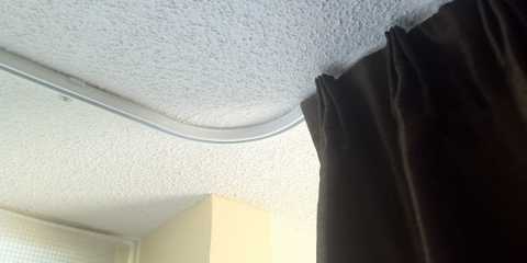 Custom bent drapery KS track for blackout curtains in a condominium
