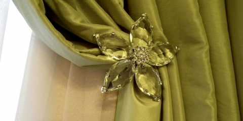 Clear crystal tiebacks on green draperies