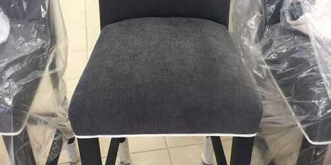 After Photo of chair upholstery in black fabric with white contrast piping