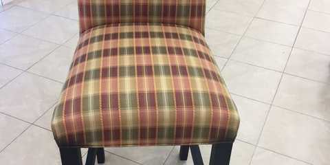 After photo of an upholstered chair with stripe fabric and matching piping