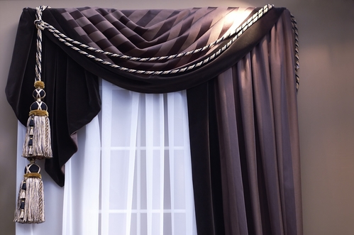brown swag curtains with tassels on window with sheers